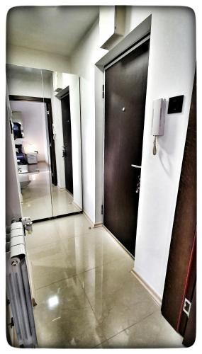 a hallway with a door and a mirror at Apartman Viena in Pasuljište