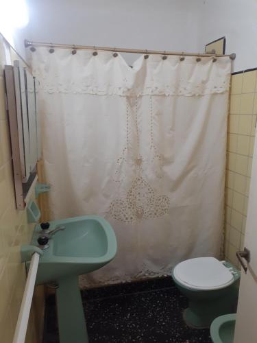 baño con lavabo verde y aseo en Casa centrica gualeguaychu en Gualeguaychú