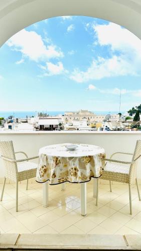 stół i krzesła na balkonie z widokiem w obiekcie Villa La Zagara by CapriRooms w mieście Capri