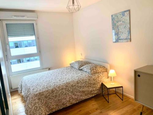 1 dormitorio con 1 cama y 1 lámpara en una mesa en Appartement cosy, en Lyon