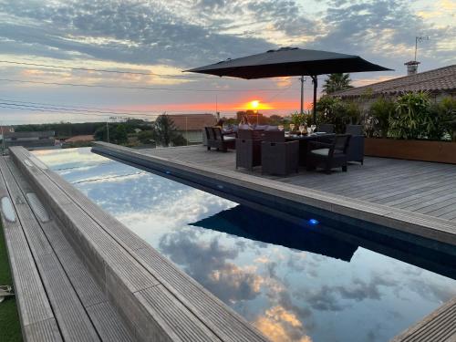 a swimming pool with a table and an umbrella at PEARL by Balgrid in Viana do Castelo