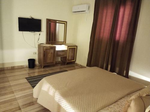 a bedroom with a bed and a mirror and a television at مدينة الشيخ زايد القاهره in Sheikh Zayed