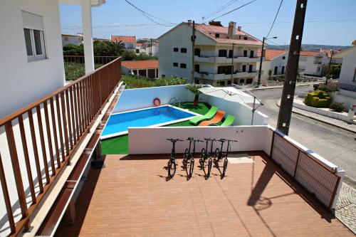 a row of bikes on a balcony with a swimming pool at Zambeachouse - Hostel Paradise in Areia Branca