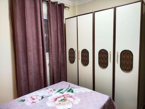 a room with a table with pink flowers on it at مدينة الشيخ زايد القاهره in Sheikh Zayed