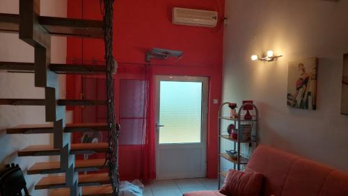 a living room with red walls and a spiral staircase at Sea Mona in Tivat