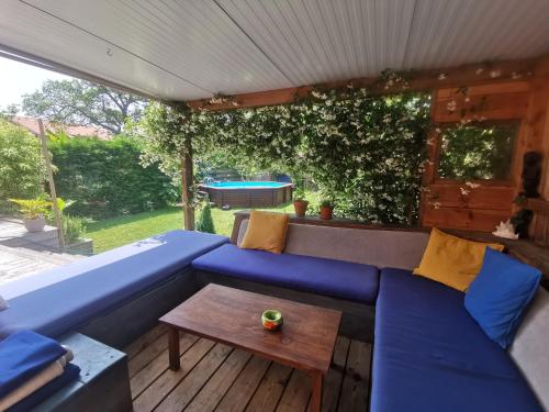 a blue couch on a wooden deck with a table at Surfworx Lodge in Soustons