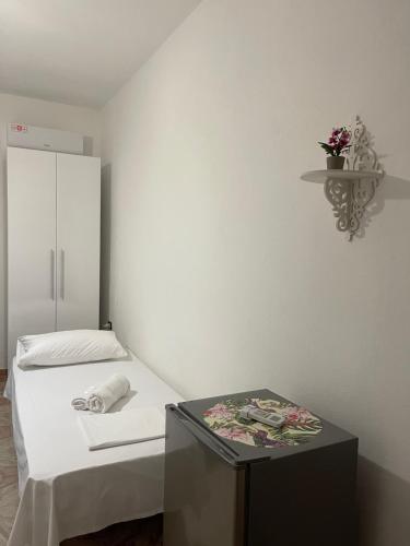 a room with a bed and a table with flowers on it at Mabel Rooms in Durrës