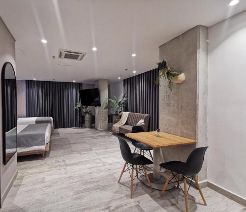 a room with a table and chairs and a bedroom at Eutopiq Hotel in Medellín