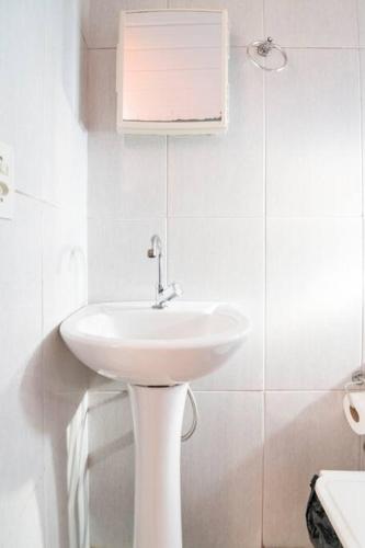 a white bathroom with a sink and a toilet at Chales Fazenda Cantinho do Selado in Monte Verde