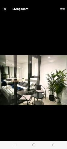 una sala de estar con muebles y plantas. en NESUTO DOCKLANDS en Melbourne