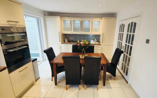 eine Küche mit einem Holztisch und schwarzen Stühlen in der Unterkunft The Bay house in Derry Londonderry