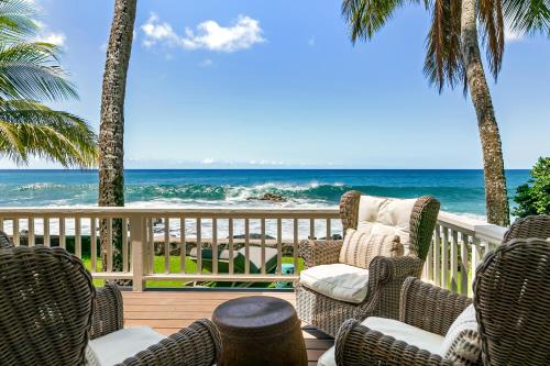 a deck with chairs and a view of the ocean at Classic 3br Oceanfront Cottage - Alekona Kauai in Koloa