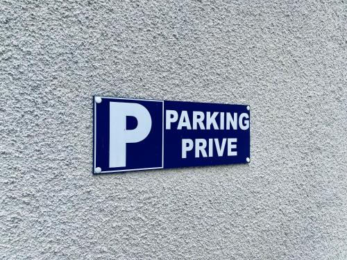 a parking sign on the side of a building at "Le Général" Appartement prestige proche gare, haut-de-gamme, avec billard et parking privé, by PRIMO C0NCIERGERIE in Nevers