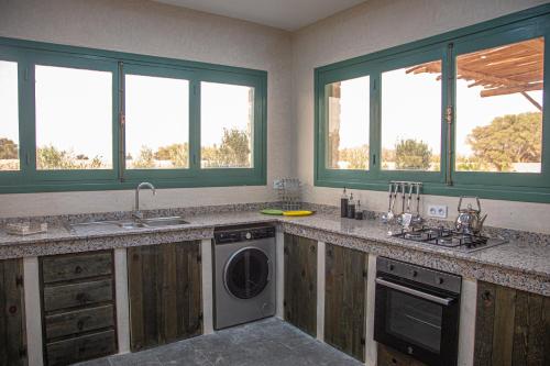 a kitchen with a sink and a washing machine at WINK house : Charme et Sérénité in Essaouira