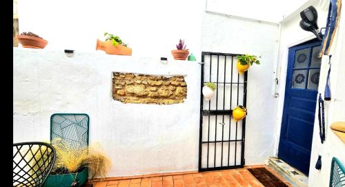a white house with a blue door and plants at Casa Bakara Vejer old town in Vejer de la Frontera