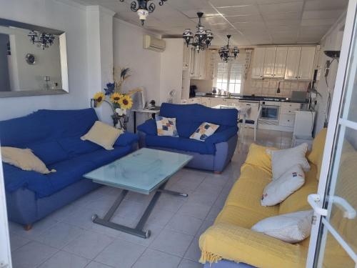 a living room with blue couches and a table at Apartamento a 4 minutos andando de la playa in Dehesa de Campoamor
