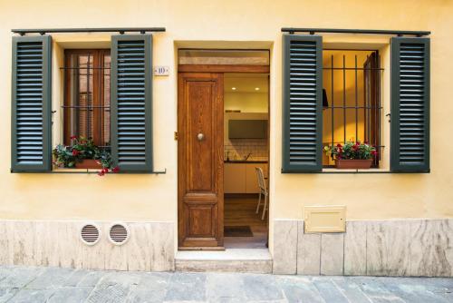 ein Haus mit blauen Fensterläden und einer Holztür in der Unterkunft Magione 10 in Siena