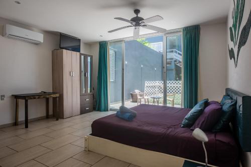 1 dormitorio con 1 cama y ventilador de techo en Iris Studios & Apartments, en Playa del Carmen