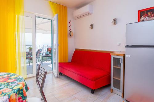 een woonkamer met een rode bank en een raam bij Apartments by the sea Medveja, Opatija - 7720 in Lovran