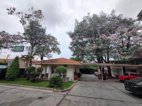 a house with flowering trees in a driveway at Villa Esmeralda in San Juan Bautista Tuxtepec