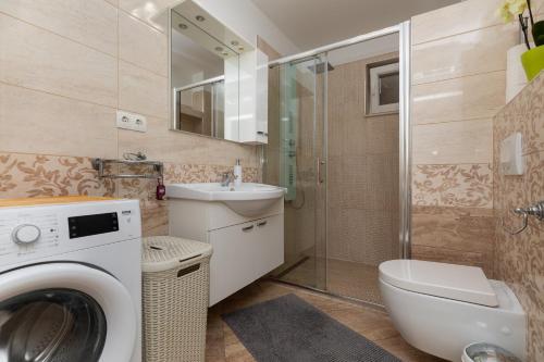 a bathroom with a washing machine and a sink at Apartments with parking space Stanici, Omis - 11421 in Celina