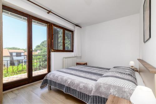 een slaapkamer met een bed en een groot raam bij Apartments by the sea Banjole, Pula - 3002 in Pula