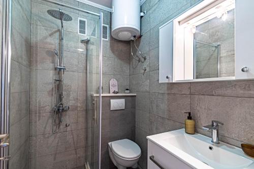 a bathroom with a shower and a toilet and a sink at Apartments by the sea Tri Zala, Korcula - 4432 in Korčula
