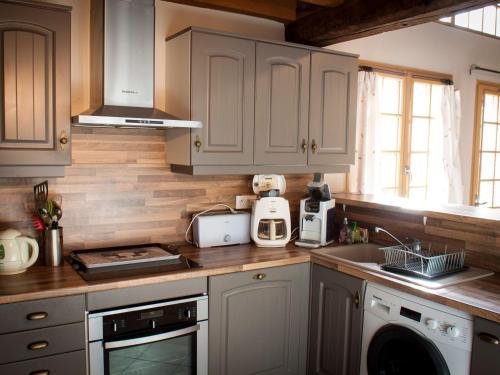 une cuisine avec des armoires blanches et un comptoir dans l'établissement Maison de campagne rénovée à 1h de Paris, avec jardin clos, 4 chambres et équipements familiaux - FR-1-590-164, à Treilles-en-Gâtinais