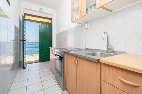 a kitchen with a sink and a view of the ocean at Seaside holiday house Preko, Ugljan - 21106 in Poljana