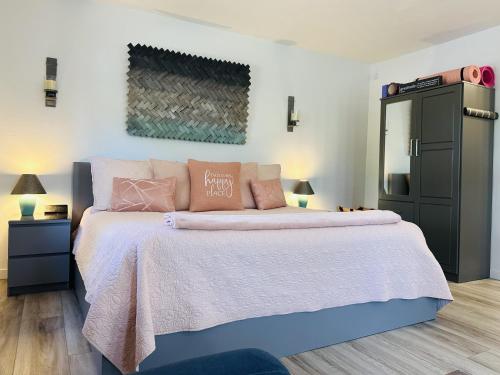 1 dormitorio con 1 cama grande con almohadas rosas en Artsy Casita, King Bed, Walk to Trails & Food, Mountain Views, Trail Pass en Sedona