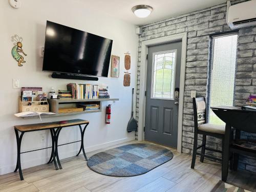 a living room with a flat screen tv on the wall at Red Rock Escape - Cozy King Bed Studio & Gardens, Trails, Views, Red Rock Pass in Sedona