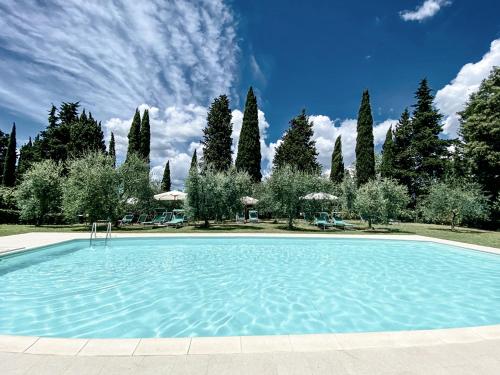 een groot zwembad met bomen op de achtergrond bij Podere San Giorgio in Palaia
