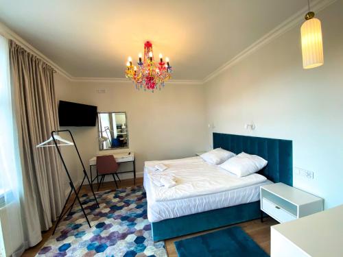 - une chambre avec un lit et un lustre dans l'établissement Apartamenty Pałacowe, à Białystok