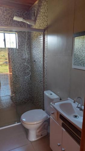 uma casa de banho com um WC, um chuveiro e um lavatório. em Cabana Entre Lagos em São Joaquim
