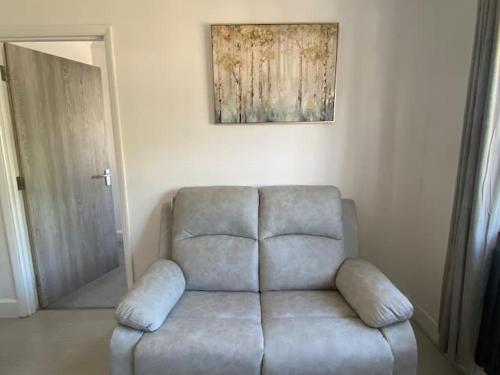 a couch in a living room with a painting on the wall at Westminster Guest House in Oxford