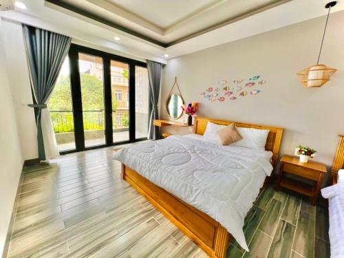 une chambre avec un lit et une grande fenêtre dans l'établissement 1A/45 Hồ Quý Ly, à Vung Tau