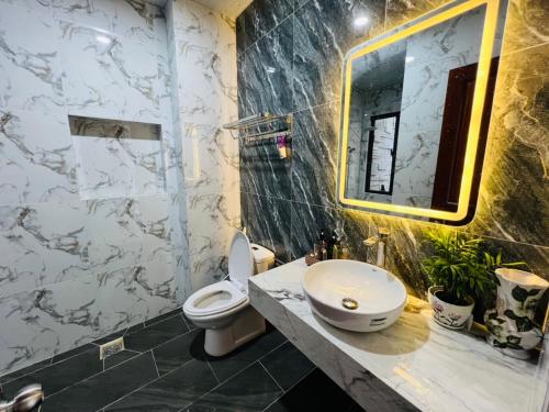 une salle de bain avec un lavabo, des toilettes et un miroir dans l'établissement 1A/45 Hồ Quý Ly, à Vung Tau