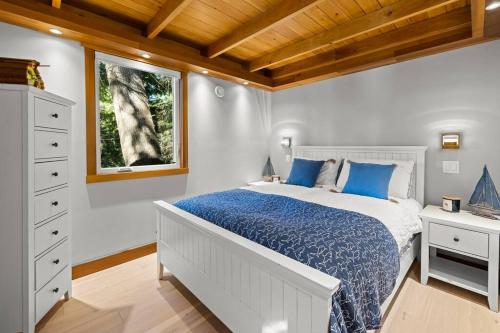 a bedroom with a large bed and a window at Kingfisher Manor in Sooke