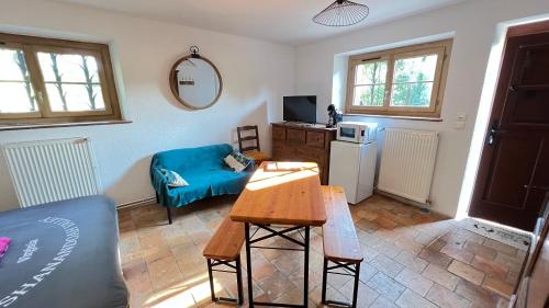 a living room with a blue couch and a table at Chambre indépendante au calme avec parking privé in Souvigny-de-Touraine