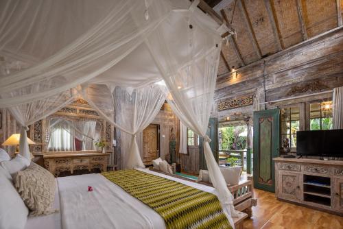 1 dormitorio con 1 cama grande con dosel en Heart of Bali Villa, en Ubud