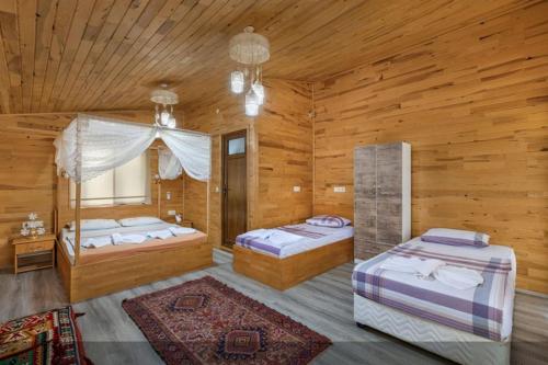 1 dormitorio con 2 camas en una habitación de madera en Flora Pansiyon Çıralı, en Kemer