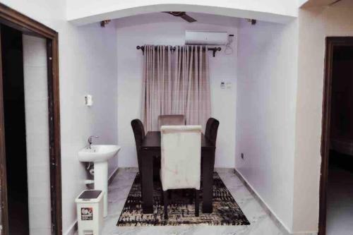 a bathroom with a sink and a table and a toilet at Cityflats Apartment in Owerri