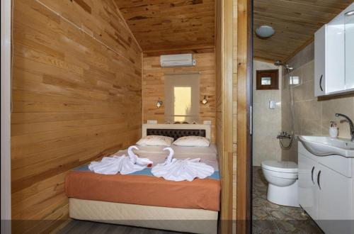 1 dormitorio con 1 cama y aseo en una habitación en Flora Pansiyon Çıralı, en Kemer
