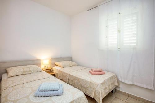 2 łóżka pojedyncze w pokoju z oknem w obiekcie Holiday house with a parking space Jadrija, Sibenik - 20641 w Szybeniku