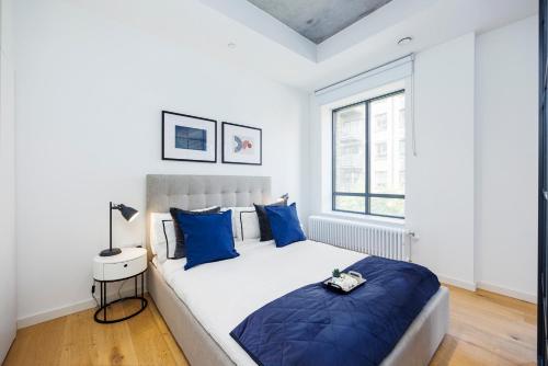 1 dormitorio con 1 cama grande con almohadas azules en Apartment Near Canary Wharf 02 Arena & Excel, en Londres