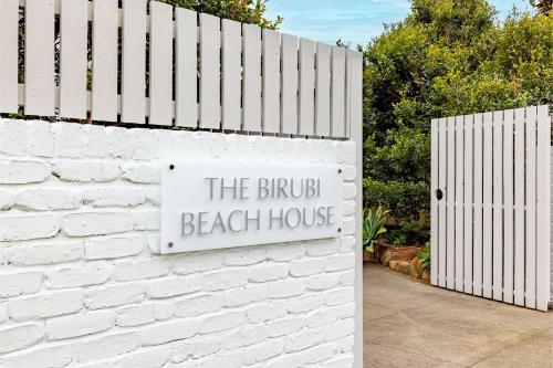 a sign that reads the bird beach house on a white wall at The Birubi Beach House 11 Campbell Ave Close to the beach pet friendly holiday home in Anna Bay