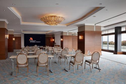 a conference room with tables and chairs and a projection screen at Istanbul Marriott Hotel Pendik in Istanbul