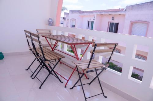 two chairs and a table on a balcony at Duplex La roseraie à 2min de la plage 2 piscines in Sidi Bouzid