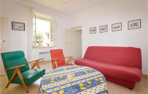 a living room with a red couch and two chairs at Cozy Apartment In Ghisoni With Kitchen in Ghisoni