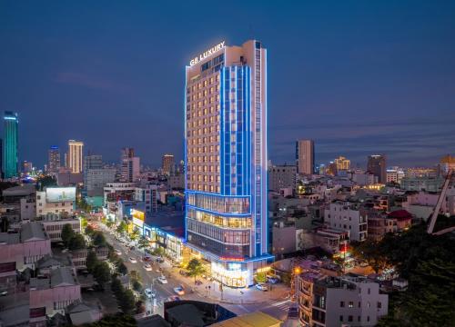 a lit up building in a city at night at G8 Luxury Hotel and Spa Da Nang in Da Nang